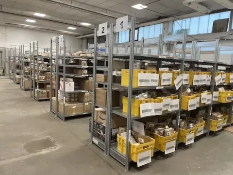 wide view of warehouse aisles with numbered shelving units and storage bins
